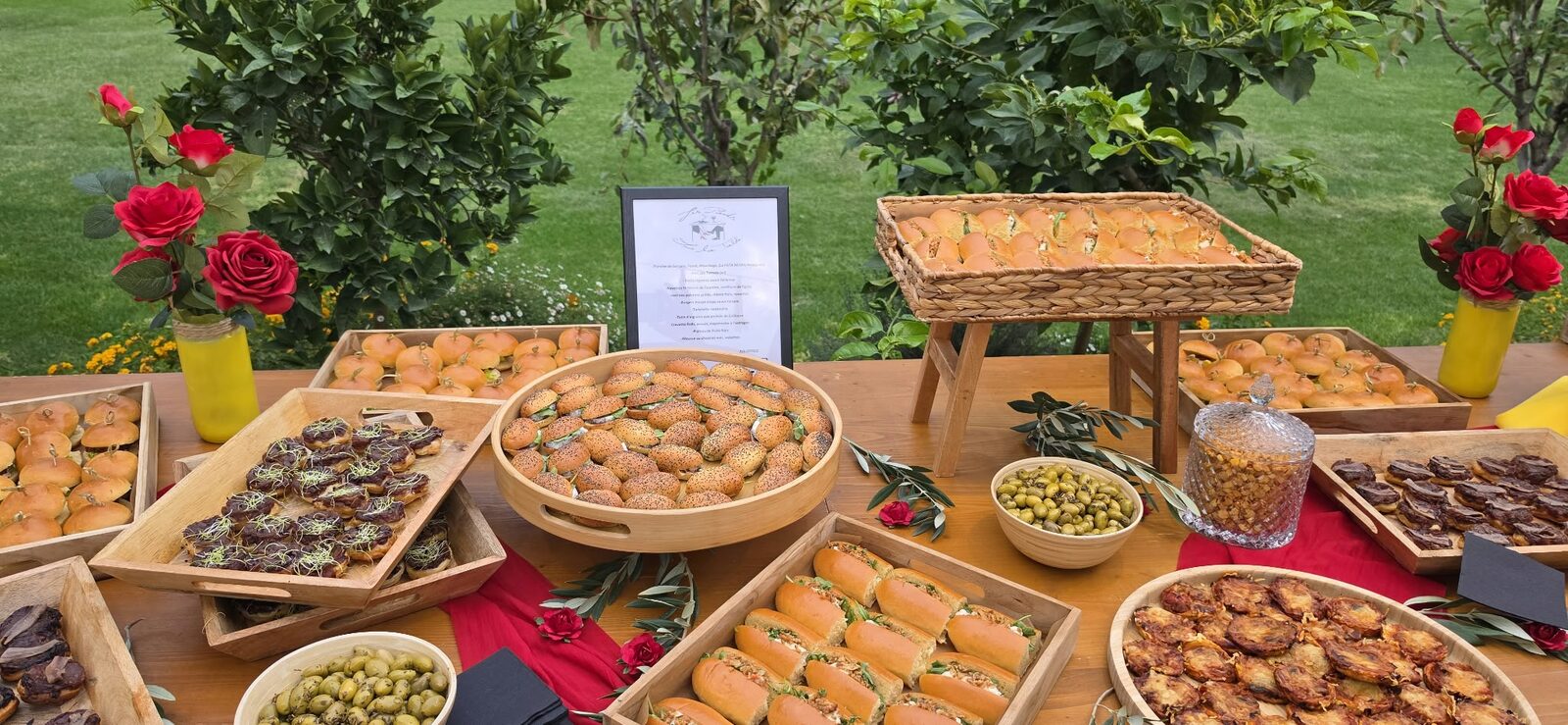 Buffet champêtre dressé sur des barriques, roses rouges et caisses en bois
